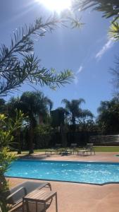 a swimming pool with tables and benches in a resort at Iguassu Express Hotel in Foz do Iguaçu