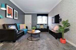 Signature - Binnie House في كومبيرنولد: غرفة معيشة مع كنب وطاولة وتلفزيون +33 صورة