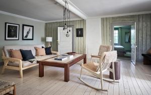 sala de estar con sofá, mesa y sillas en Kungs Starby Gård Bed and Breakfast, en Vadstena