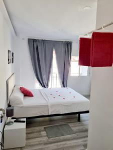 a bedroom with a bed with red pillows and a window at Apartamentos T5 Valencia in Torrent