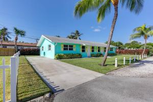ein blaues Haus mit Palmen davor in der Unterkunft Palm Beach Townhome 4 Mi to Juno Beach Park! in North Palm Beach