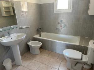 een badkamer met een wastafel, een toilet en een ligbad bij Résidence les chênes in Borgo +37 foto's