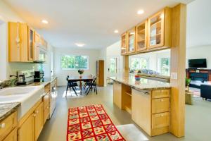 a kitchen with wooden cabinets and a kitchen with a table at Quaint Charlottesville Home Less Than 10 Mi to Dtwn! in Earlysville