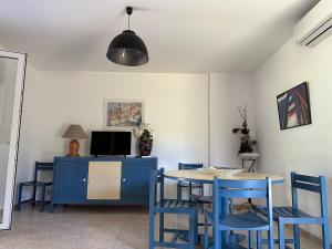 una sala da pranzo con tavolo e sedie blu di Résidence les chênes a Borgo