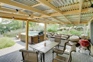 eine Terrasse mit einem Tisch und Stühlen sowie einem Whirlpool in der Unterkunft Couples Cabin - Upper Unit with Deck on Eagle Lake in Big Lake