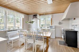 a kitchen with a wooden ceiling and a table and chairs at Prästänge in Vallsta
