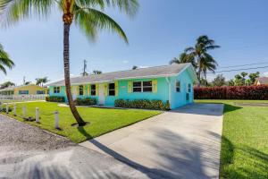 una casa azul y amarilla con una palmera en Pet-Friendly Palm Beach Pad - 1 Mi to the Ocean!, en North Palm Beach