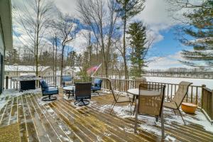 una terraza con sillas, mesa y chimenea en Cozy Lakeside Cottage Pontoon, Kayaks, Grill, en Newaygo