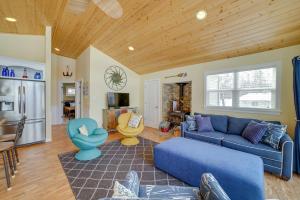un soggiorno con divano blu e una cucina di Cozy Lakeside Cottage Pontoon, Kayaks, Grill a Newaygo