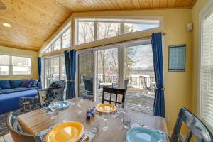 uma sala de jantar com uma mesa e uma grande janela em Cozy Lakeside Cottage Pontoon, Kayaks, Grill em Newaygo