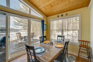 a dining room with a table and chairs and windows at Fish, Hike and Hunt Lakeside Newaygo Cottage in Newaygo +26 photos