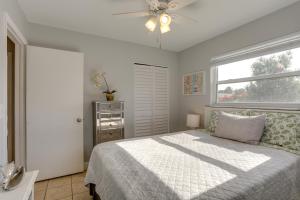 Schlafzimmer mit einem Bett, einem Deckenventilator und einem Fenster in der Unterkunft Coastal Townhome with Patio about 2 Mi to Beach! in North Palm Beach