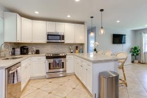 ノース・パーム・ビーチにある2 Mi to Swim and Shop Updated North Palm Beach Homeの白いキャビネットとコンロ付きオーブンを備えたキッチン