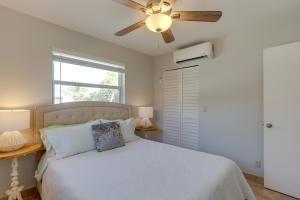 een slaapkamer met een wit bed en een plafondventilator bij Stylish Updated Getaway 2 Mi to Swim and Shop! in North Palm Beach