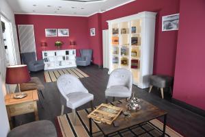 a living room with red walls and a table and chairs at Carat Hotel Grömitz in Grömitz