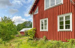 una casa roja con dos ventanas en el lateral. en 4 Bedroom Beautiful Home In Vimmerby, en Vimmerby