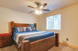 a bedroom with a bed with a ceiling fan and a window at Duck Creek Village Cabin with Fire Pit and Grill! in Duck Creek Village