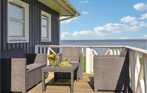 um alpendre com duas cadeiras e uma mesa com flores em Beautiful Home In Vinderup With House Sea View em Vinderup