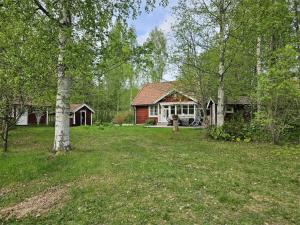 a house in the middle of a yard with trees at Prästänge in Vallsta