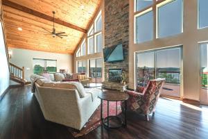 ein Wohnzimmer mit einem Sofa, Stühlen und Fenstern in der Unterkunft Luxe Table Rock Lake Vacation Rental with Hot Tub! in Lampe