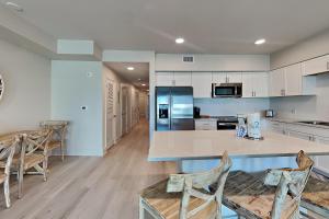 a large kitchen with a counter and chairs in it at Sea Glass #211 in Gulf Shores