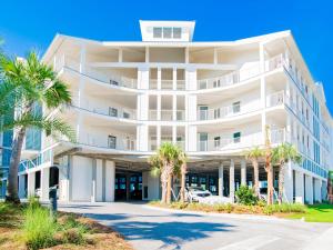 a white building with palm trees in front of it at Sea Glass #211 in Gulf Shores