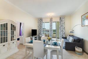 ein Wohnzimmer mit einem Tisch und einem Sofa in der Unterkunft Lake Apartments - 1BR Apartment - Allsopp&Allsopp in Dubai