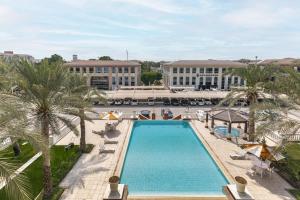 an overhead view of a pool with palm trees and buildings at Lake Apartments - 1BR Apartment - Allsopp&Allsopp in Dubai