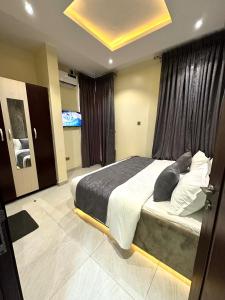 una camera con un grande letto e una grande finestra di GOD'S TOUCH APARTMENTS SHORT-LET Adenugba Street Oregun Ikeja Lagos Nigeria a Ikeja