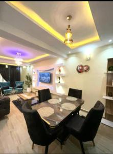 ein Wohnzimmer mit einem Esstisch und Stühlen in der Unterkunft GOD'S TOUCH APARTMENTS SHORT-LET Adenugba Street Oregun Ikeja Lagos Nigeria in Ikeja