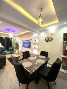 ein Esszimmer mit einem Tisch und Stühlen im Wohnzimmer in der Unterkunft GOD'S TOUCH APARTMENTS SHORT-LET Adenugba Street Oregun Ikeja Lagos Nigeria in Ikeja