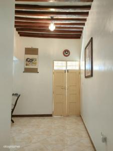 a hallway with white walls and a wooden ceiling at Manama Suites Apartment in Lamu