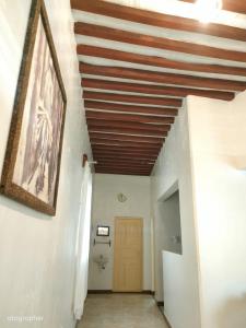 a hallway with a wooden ceiling and a door at Manama Suites Apartment in Lamu