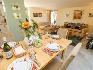 a living room with a wooden table with a vase of flowers at Garstons Barn in Newport