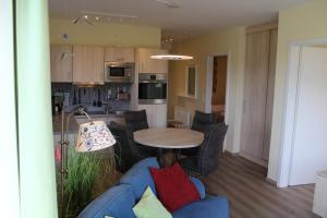 a living room with a blue couch and a table at LM 9-1-1 - Ferienwohnung Wremer Bogen Komfort in Schottwarden