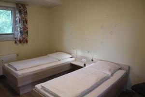 two beds in a small room with a window at LM 9-1-1 - Ferienwohnung Wremer Bogen Komfort in Schottwarden