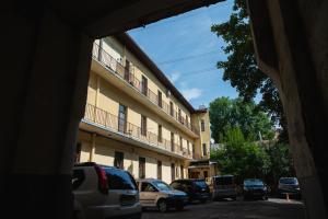 a building with cars parked in a parking lot at One bedroom apartment with balcony-Kostyushka street,16 in Lviv