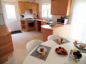 a kitchen with a table with a plate of food on it at Signature - Brambling House in Coatbridge
