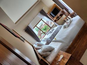 a bedroom with a bed and a window at Semilir Inn Senggigi in Senggigi 