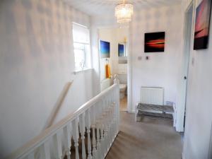 コートブリッジにあるSignature - Brambling Houseの白い廊下(階段、シャンデリア付)