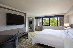 a hotel room with a large bed and a flat screen tv at Portland Sheraton at Sable Oaks in South Portland