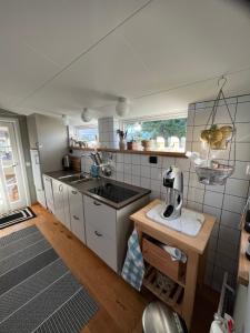 una pequeña cocina con fregadero y encimera en Eget boende i privat uthuslänga, en Alingsås