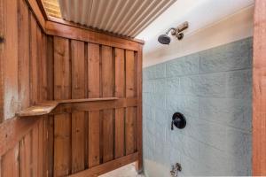 a bathroom with a wooden door and a shower at Beach Please in Port Aransas +13 photos