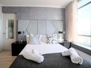 a bedroom with a large white bed with towels on it at Masingita Towers Hotel and SPA in Johannesburg