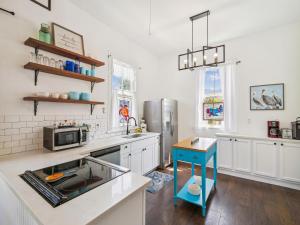 una cucina con armadi bianchi e isola blu di The Vintage Sea Turtle a Galveston