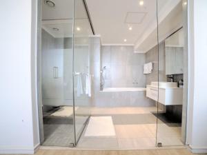 a bathroom with a shower and a tub and a sink at Masingita Towers Hotel and SPA in Johannesburg