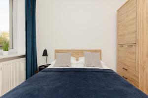 sypialnia z dużym łóżkiem z drewnianym zagłówkiem w obiekcie Ursus Spacious Two-bedroom Apartment by Renters w Warszawie