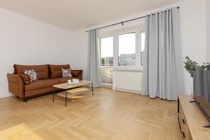 salon z kanapą i stołem w obiekcie Ursus Spacious Two-bedroom Apartment by Renters w Warszawie
