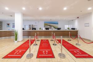 a lobby with red carpets on the floor at Carat Apartments Grömitz in Grömitz