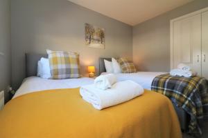 2 camas con toallas encima de ellas en un dormitorio en Signature - Whistleberry House en Hamilton